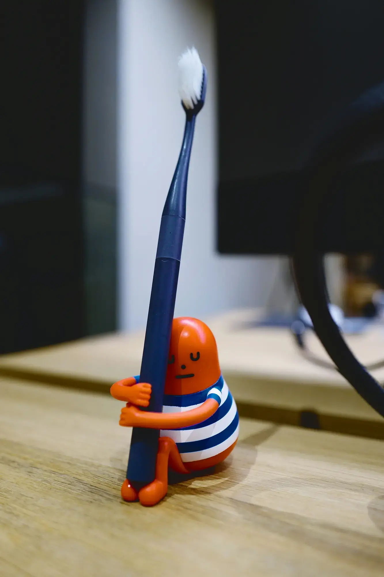 Kleine Figur mit Zahnbürste als Symbol für spielerische Zahnpflege.