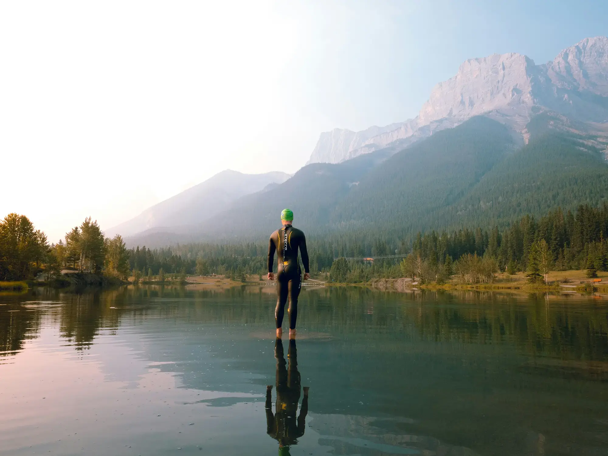 Person in einem Bergsee inmitten einer alpinen Landschaft.